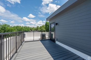 A balcony with a railing and a door leading to a house. at Park Lamont Townhomes Apartments, Cleveland, Ohio
